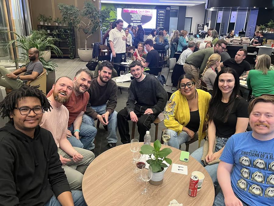 Kubicle team at an industry meet‑up, gathered around a small table with a plant centrepiece.